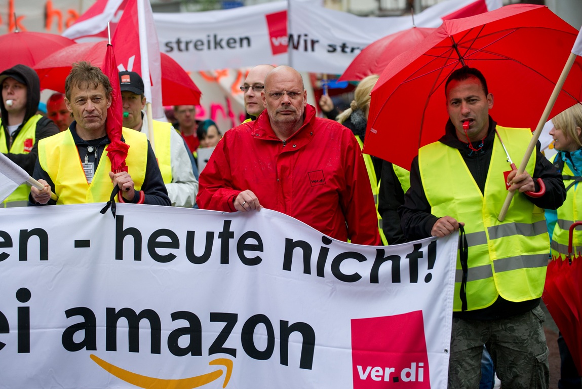 Logistic center employees of Amazon march through Bad Hersfeld, western Germany, during a strike on May 14, 2013. German employees of Amazon staged their first-ever walkouts as the US Internet retail giant was hit by a dispute over pay. Germany's giant services sector union Verdi is demanding that Amazon's 9,000 employees in Germany be paid according to a sector-wide wage deal for the retail and mail-order industries.     AFP PHOTO / UWE ZUCCHI / GERMANY OUT        (Photo credit should read UWE ZUCCHI/AFP/Getty Images)