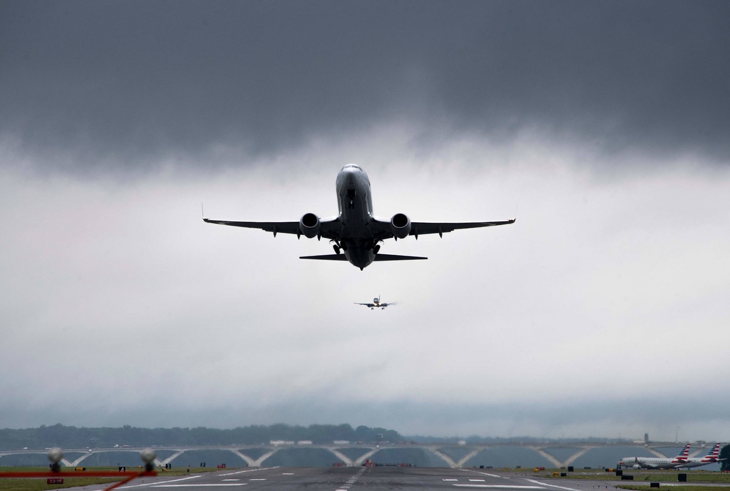 A flight takes off as another lands at Ronald Reagan Washington National Airport in Arlington, Virginia, on July 8, 2019, after a storm delayed flights. (Photo by Jim WATSON / AFP)        (Photo credit should read JIM WATSON/AFP via Getty Images)